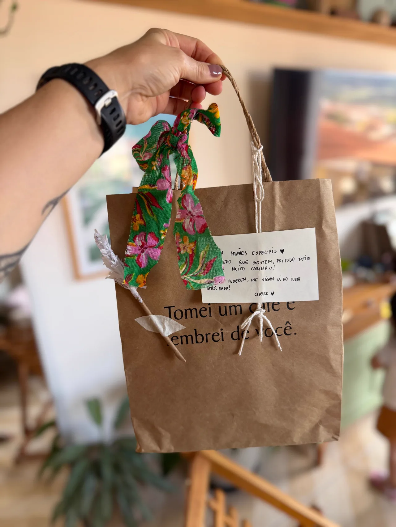 Kit de presente da Patês da Rafa sobre a mesa, com potes de patê, pão e a garrafa pintada à mão