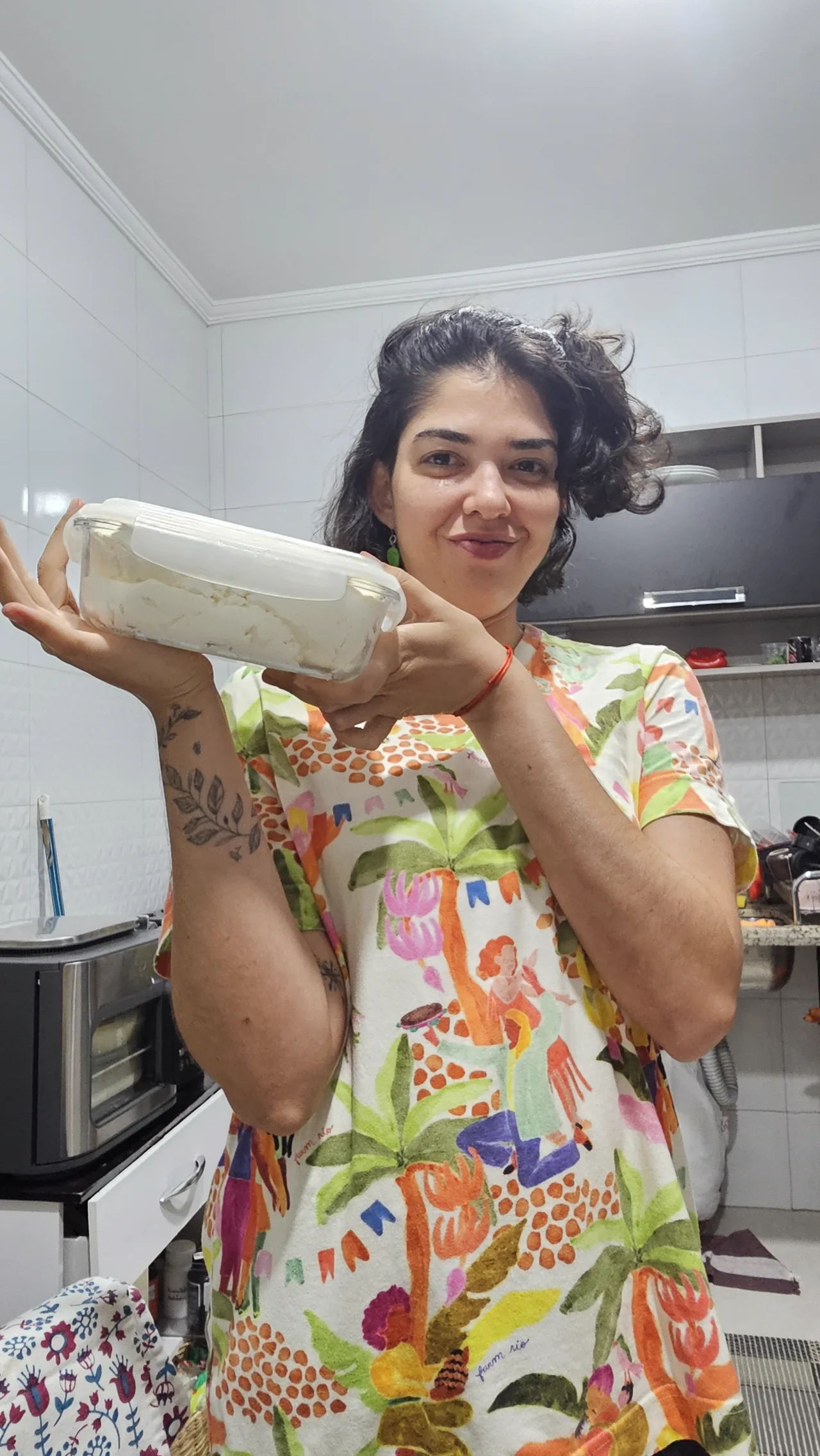Rafa na cozinha, segurando um pote de labneh